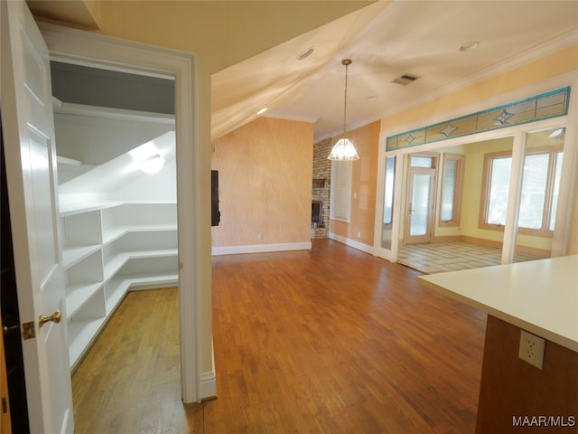 interior space featuring crown molding, wood-type flooring, and a fireplace