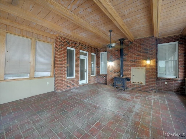 interior space featuring a wood stove and beamed ceiling