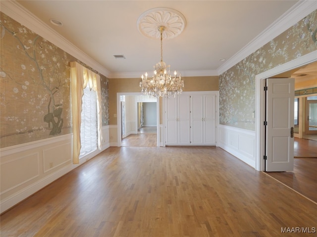 unfurnished dining area featuring ornamental molding, a wealth of natural light, and light wood-type flooring