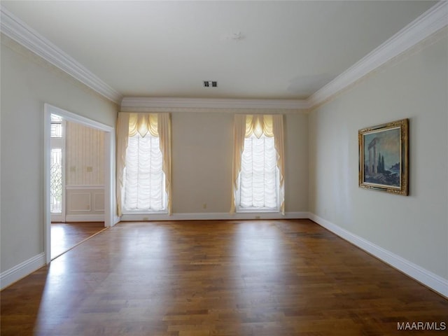 empty room featuring visible vents, wood finished floors, baseboards, and ornamental molding