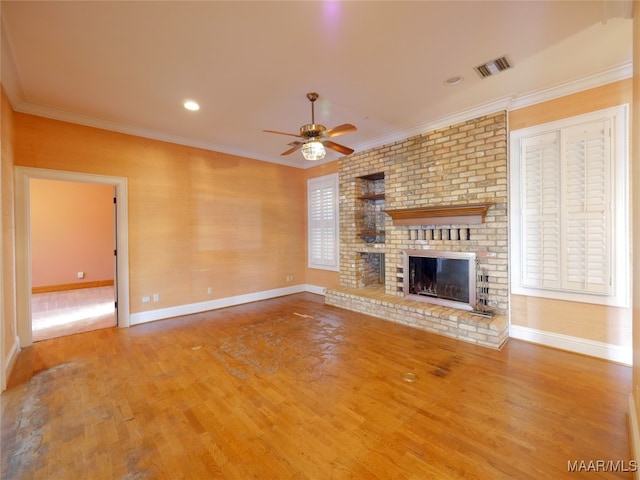 unfurnished living room featuring ceiling fan, ornamental molding, a fireplace, and hardwood / wood-style floors