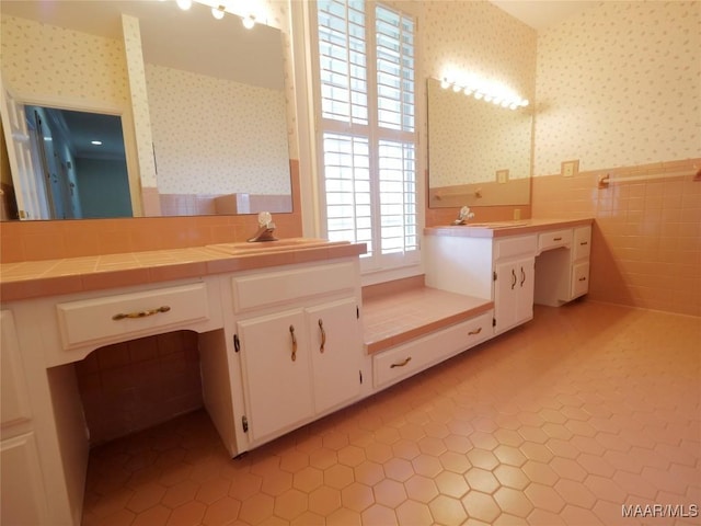 full bathroom featuring tile walls, wallpapered walls, tile patterned flooring, and a wainscoted wall