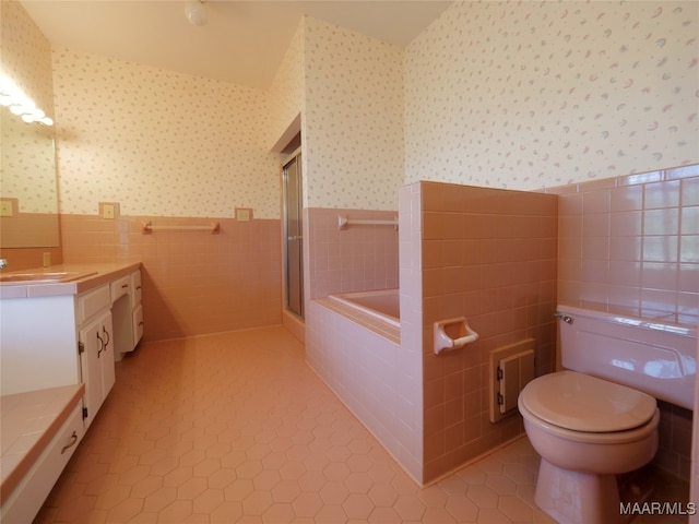 full bathroom with vanity, independent shower and bath, toilet, and tile walls