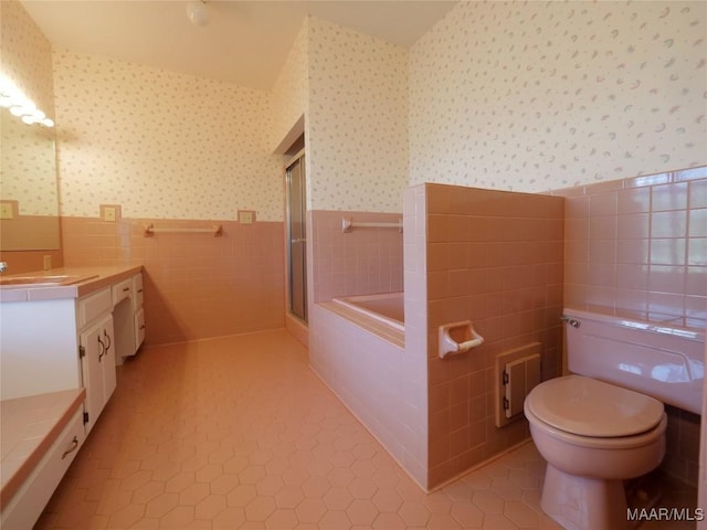 bathroom with tile walls, tile patterned flooring, wallpapered walls, and a wainscoted wall