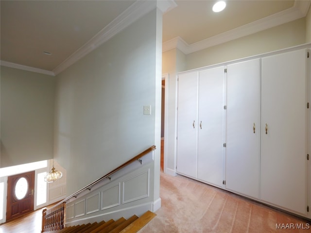 staircase featuring crown molding, carpet floors, and a chandelier