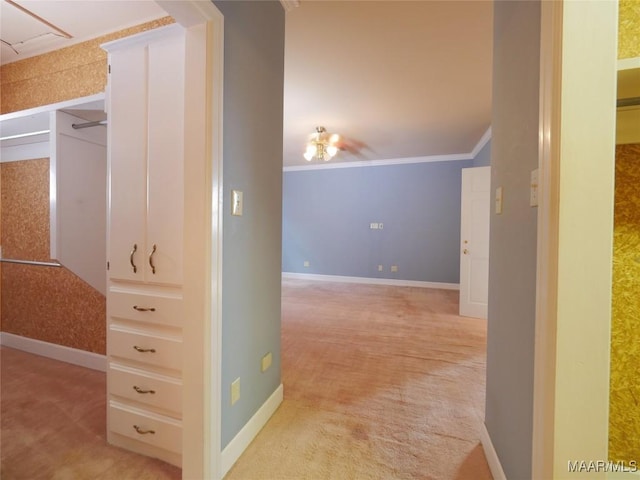 hallway featuring light colored carpet, ornamental molding, and baseboards