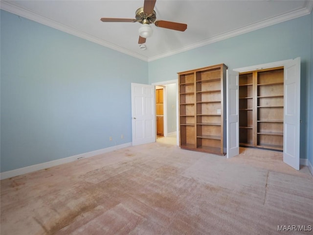 unfurnished bedroom featuring crown molding, baseboards, ceiling fan, and carpet floors