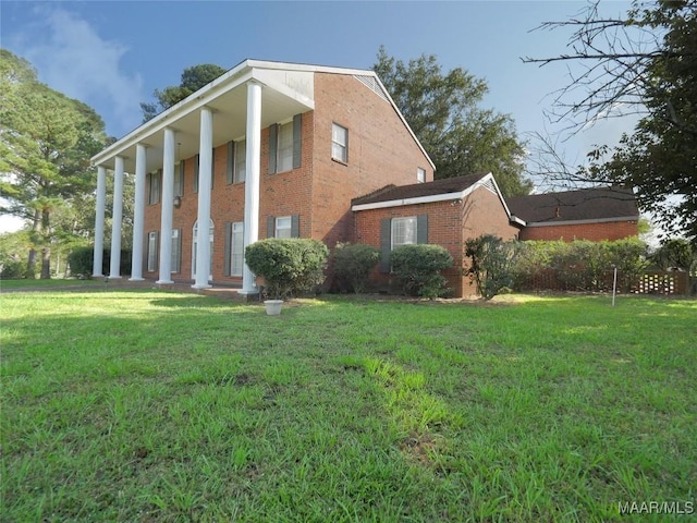 view of side of property with brick siding and a lawn
