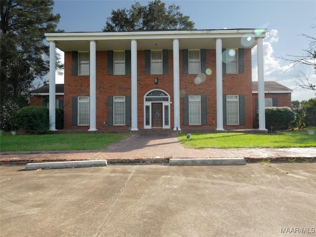 neoclassical home with covered porch and brick siding