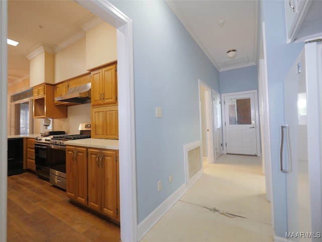 kitchen featuring light hardwood / wood-style flooring, crown molding, stainless steel range with gas cooktop, and exhaust hood