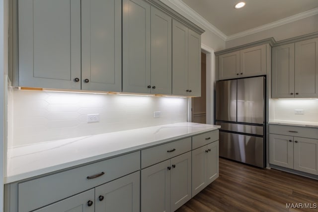 kitchen featuring ornamental molding, stainless steel fridge, light stone countertops, gray cabinets, and dark hardwood / wood-style flooring