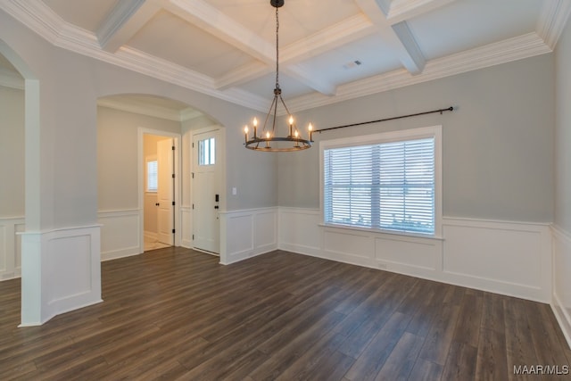 empty room featuring beam ceiling, coffered ceiling, crown molding, a chandelier, and dark hardwood / wood-style floors