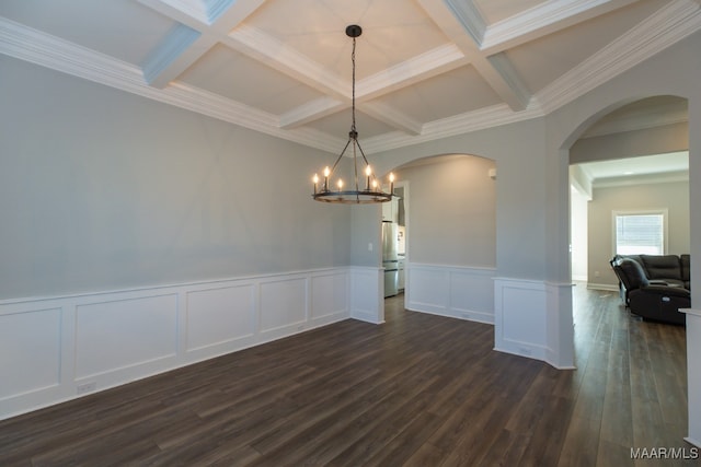 unfurnished dining area featuring beamed ceiling, dark wood-type flooring, ornamental molding, and coffered ceiling