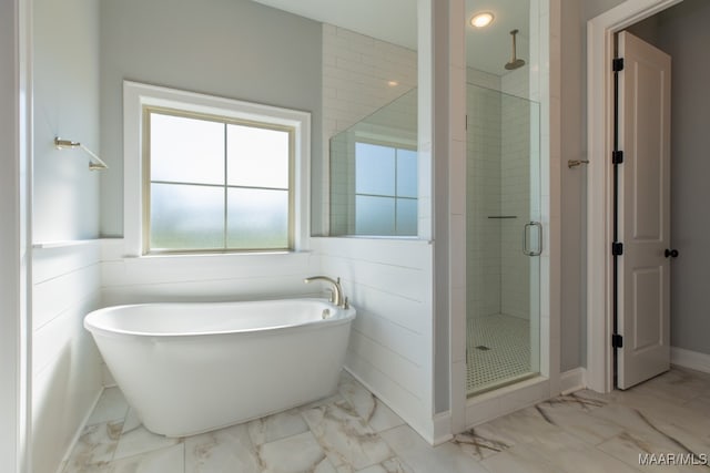 bathroom featuring shower with separate bathtub