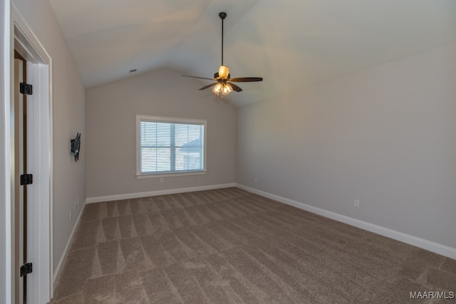 carpeted spare room featuring vaulted ceiling and ceiling fan