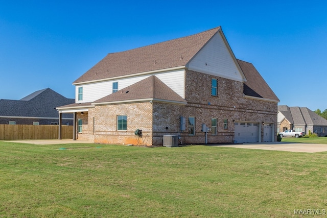 back of house with cooling unit, a yard, and a garage