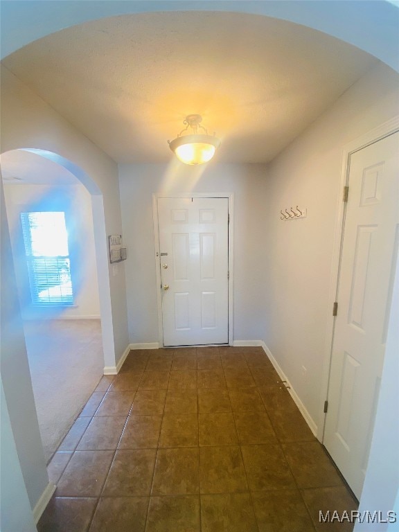 doorway featuring dark tile patterned flooring