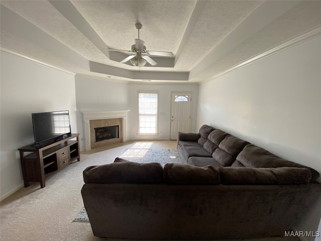 carpeted living room featuring ceiling fan, a raised ceiling, and a textured ceiling