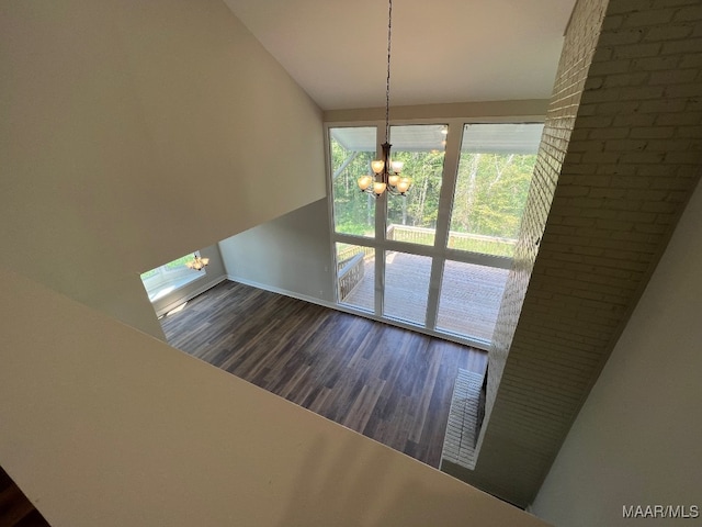 unfurnished dining area with dark hardwood / wood-style flooring and a chandelier