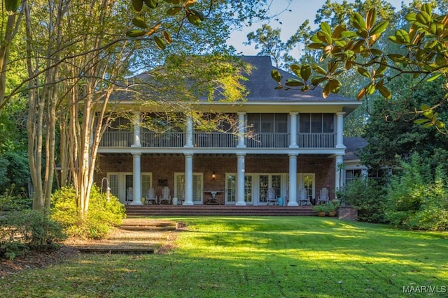 back of property with a lawn and french doors