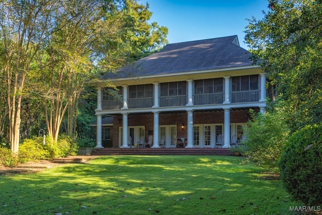 back of house with french doors and a lawn