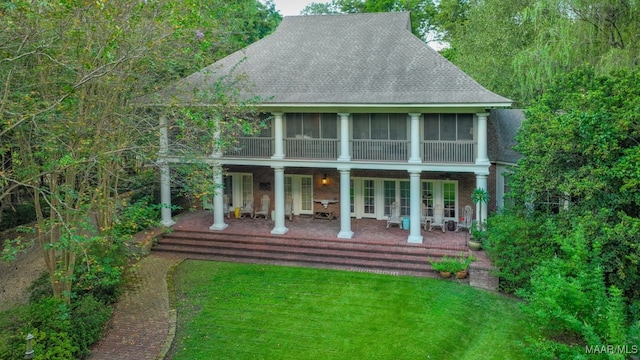 back of house featuring a yard and a sunroom