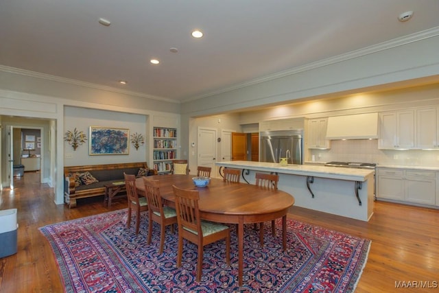 dining space with crown molding and light hardwood / wood-style flooring