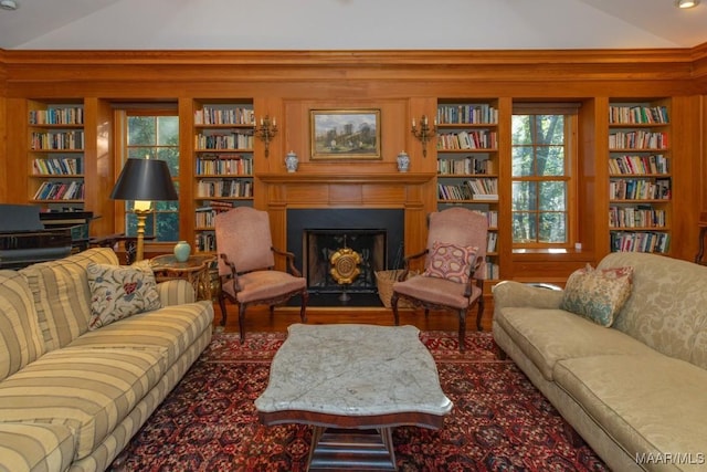 living room with lofted ceiling, plenty of natural light, and built in shelves