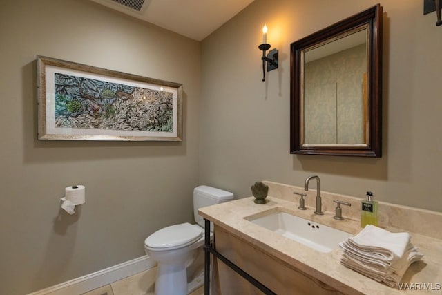 bathroom with tile patterned flooring, vanity, and toilet