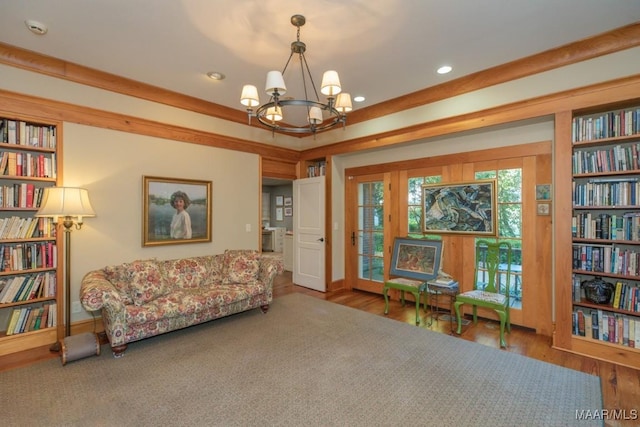 living area featuring hardwood / wood-style flooring, built in features, and a chandelier