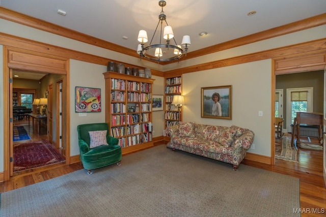 sitting room with an inviting chandelier and hardwood / wood-style flooring