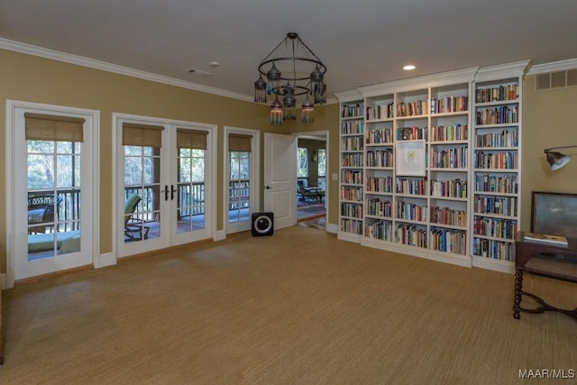 unfurnished room featuring a notable chandelier, ornamental molding, french doors, and carpet flooring