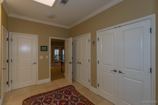 hall featuring crown molding and light tile patterned floors