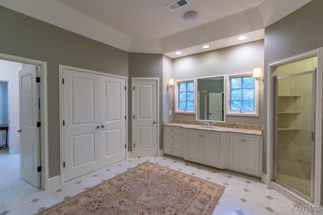 bathroom with a shower with door and vanity