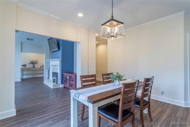 dining area featuring dark hardwood / wood-style flooring, a chandelier, and ornamental molding