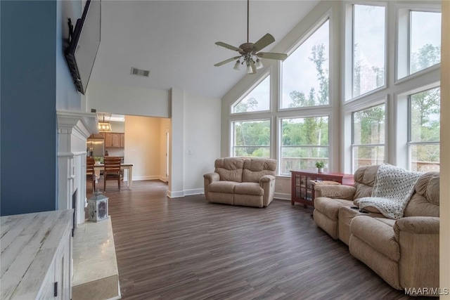 living area featuring high vaulted ceiling, wood finished floors, visible vents, baseboards, and a ceiling fan