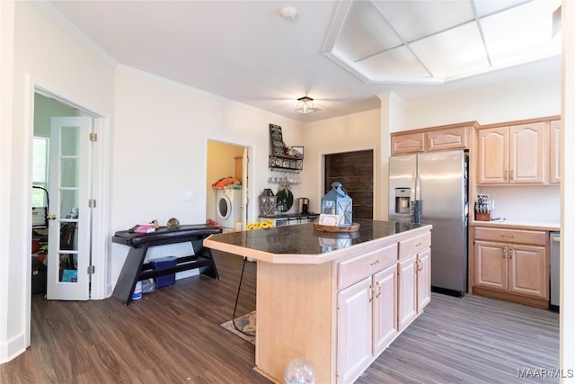 kitchen with a breakfast bar, dark wood finished floors, appliances with stainless steel finishes, light brown cabinets, and a kitchen island