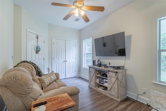 living room with dark hardwood / wood-style flooring, plenty of natural light, and ceiling fan