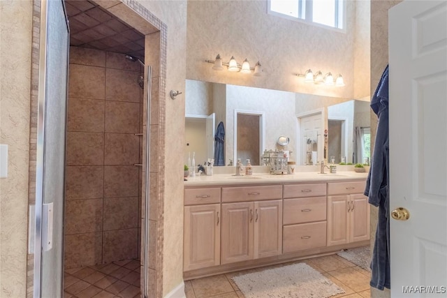 full bath featuring double vanity, a stall shower, tile patterned flooring, and a sink