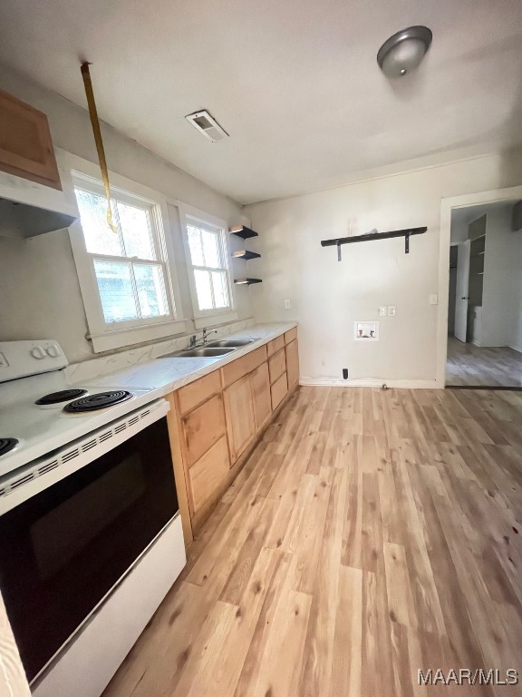 kitchen with sink, pendant lighting, light brown cabinetry, light hardwood / wood-style floors, and electric stove