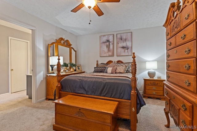 bedroom featuring a textured ceiling, light colored carpet, and ceiling fan