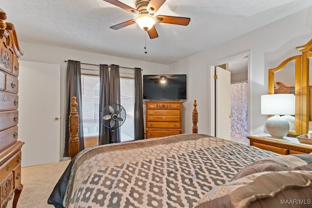 carpeted bedroom featuring ceiling fan and a textured ceiling