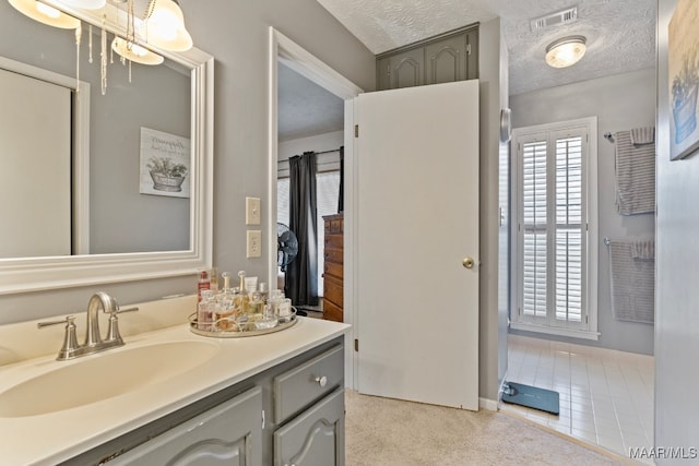 bathroom featuring tile patterned floors, vanity, and a textured ceiling