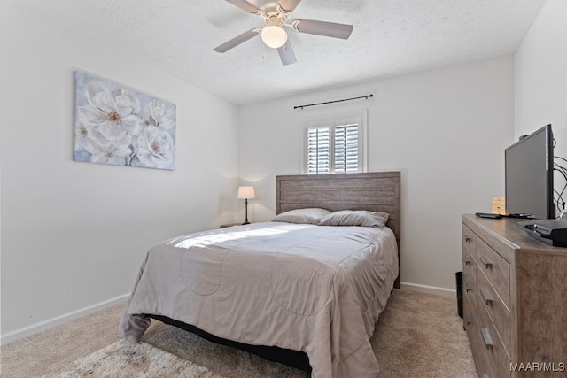 carpeted bedroom featuring ceiling fan and a textured ceiling