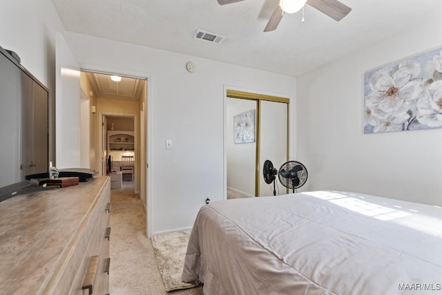 carpeted bedroom with a textured ceiling, a closet, and ceiling fan