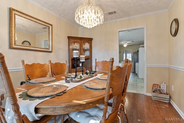 dining area featuring ceiling fan with notable chandelier, a textured ceiling, crown molding, and dark wood-type flooring