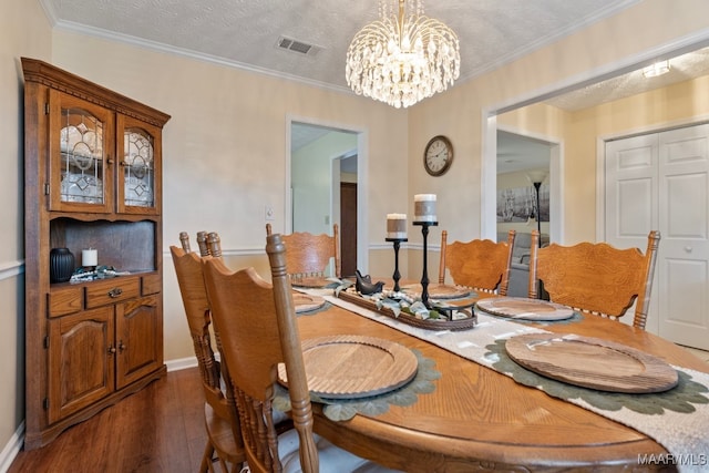 dining room featuring a chandelier, ornamental molding, a textured ceiling, and dark wood-type flooring