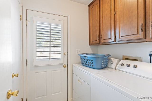 washroom featuring separate washer and dryer and cabinets