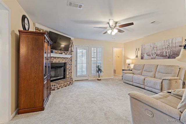 living room featuring ceiling fan, a fireplace, and light carpet