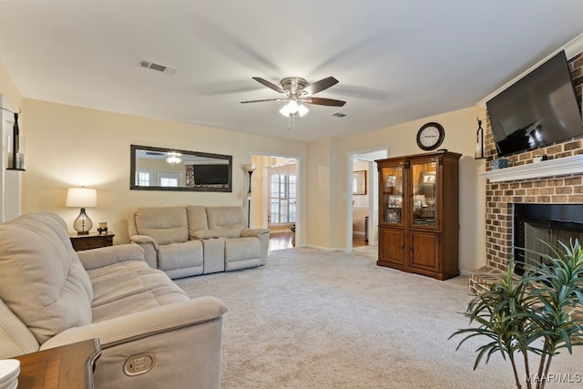 living room with light colored carpet, a brick fireplace, and ceiling fan